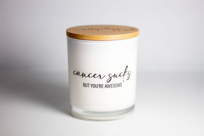 This printed candle reads "Cancer sucks but you're awesome".  Provide any home with a beautiful décor item while filling the room with a beautiful fragrance! The words are printed directly onto the milky-white glass vessel to give a crisp, clean look to each candle.  100% Pure Soy Wax | Premium Fragrance Oils | Lead-free cotton wick | 11.5 oz. | 75-80 hrs burn time | Includes engraved bamboo lid | 3.5” W x 4” H