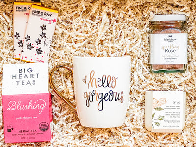 Celebrate the extraordinary women in your life with our exclusive "Gorgeous Moments Gift Box", a carefully curated ensemble perfect for Mother's Day. This indulgent gift set includes a "Hello Gorgeous" white mug with elegant gold letters and handle, exuding warmth and style with every sip. Savor the soothing flavors of our 'Blushing' pink hibiscus organic tea, crafted with 10 convenient tea sachets for moments of tranquility.