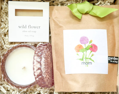 Gift your a mother this “Bloom and Glow” gift set that’s sure to delight her senses and brighten her room. The set includes a “mom” zinnia garden in-a-bag, a petite shimmer candle in a peony scent, and a pure and natural wildflower olive oil soap.