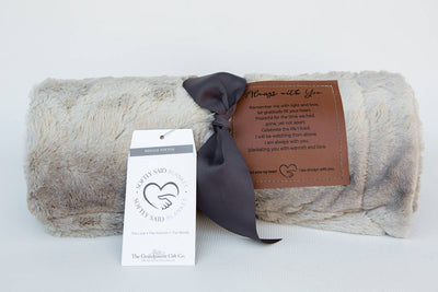 Our "Softly Said" Always with You, comforting blanket measures 50"x65" and is overflowing with warmth and comfort. The faux fur and micro mink gray-toned blanket is an absolute gift for mind, body, and soul. A loving message is embossed on a faux leather label and sewn on the blanket for the recipient to remember your message each time it is used.
