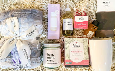 This new mom gift set is the perfect way to show that special mom in your life that you care. It has everything she needs to pamper herself, including a heat wrap to relax her muscles, a "Best Mom Ever" soy candle to fill her home with a soothing scent, Milkmaid tea to help her relax, honey to sweeten the cup, a mug to cozy up with, dark chocolate for a much-needed pick-me-up, nipple butter to soothe her changing body, French lavender body oil to nurture her skin, and shower steamers to set the mood. This g