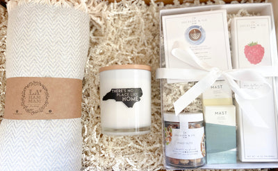 There really is no place like home!  If they currently live in North Carolina, or call NC home, this gift set will definitely bring a smile to their face.  The sugar citrus scent of the large soy candle is addicting and we love how it has a crisp, clean look.  The large Turkish blanket is so versatile and comfortable.  Snacks are packed together nicely in a white box with a clear lid.  The mini snack items include: pour over coffee, raspberry cookies, mixed nuts, two chocolates.  